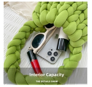 Detail view of grass green chunky knit bag interior with phone and sunglasses