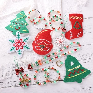 Flat lay of Christmas DIY jewelry kit with felt charms and Merry Christmas letter beads