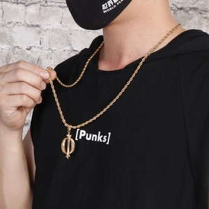 Détail d'une chaîne corde dorée avec pendentif épée et cercle portée par un mannequin homme