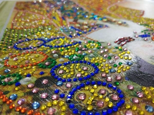 Macro shot of colorful faceted resin diamonds on a 5D Christmas wreath DIY diamond painting