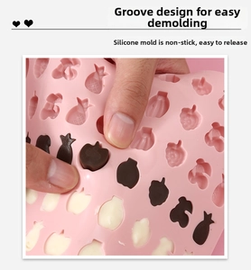 Detail of flexible pink silicone fruit mold showing easy demolding of chocolate shapes