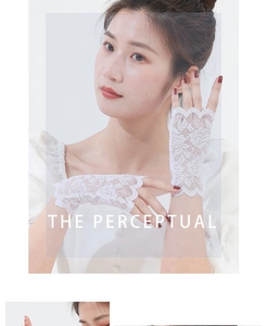 Close-up of white lace fingerless gloves with elegant rose floral embroidery and scalloped edges
