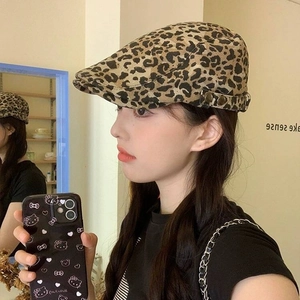 Detail view of khaki leopard print newsboy cap with side metal buckle on model