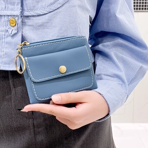 Blue leather coin purse with golden snap button and key ring shown in hand