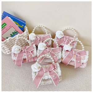 Detail of tweed girls' handbags with pearl bead handles and pink satin ribbon bows