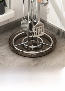 Close-up of rotating kitchen utensil holder with stainless steel tools and drip tray
