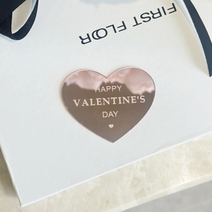 Gros plan d'un topper de gâteau cœur en or rose avec gravure Happy Valentine's Day