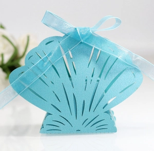 Detail of light blue shell gift box featuring laser-cut patterns and a silk ribbon bow