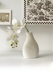 Detail of white ceramic vase with spiral texture and elegant white orchid decoration