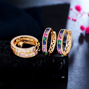 Macro shot of gold earrings with multi-color square cubic zirconia in claw settings