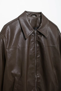 Close-up of vintage dark brown faux leather pilot jacket with silver metal zipper detail