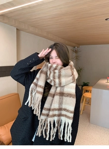 Close-up of the beige and brown checkered scarf texture with soft tassel details