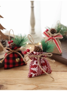 Close-up of Christmas linen gift bags with pine cones and berries on a wooden surface