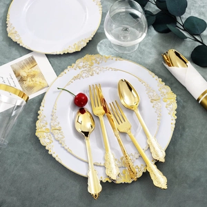 Detail of white relief dinner plate with gold lace edge and baroque carved cutlery set