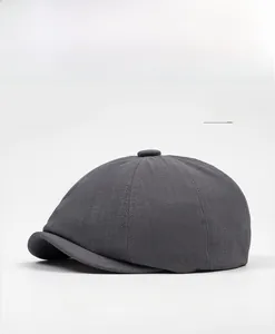 Detail of grey newsboy cap showing twill fabric texture and six-panel stitching
