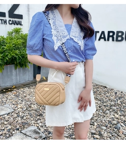 Close-up of khaki quilted leather crossbody bag with wide logo textile shoulder strap