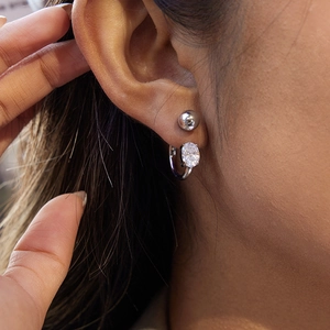 Detailed close-up of a silver stainless steel double-hole earring with zircon stone