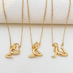 Kreative goldene Yoga-Anhänger an Halsketten auf weißem strukturiertem Steinhintergrund