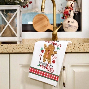 Christmas dish towel with gingerbread man print hanging on a kitchen drawer handle
