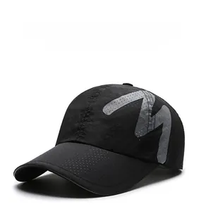 Detail view of breathable laser-cut holes and reflective M logo on black outdoor mesh cap
