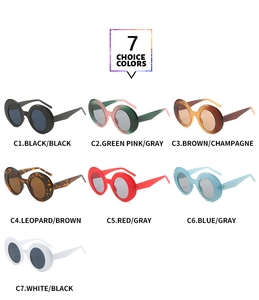 Flat lay display of thick round retro sunglasses in 7 color choices on white backdrop