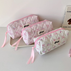 Close-up of quilted floral pencil cases with cute bowknot details and long ribbon zippers