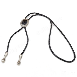 Detail of patterned agate stone bolo tie with black braided leather cord and silver metal slider