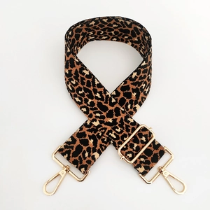 Détail de la bandoulière léopard avec mousquetons dorés et boucle de réglage en métal