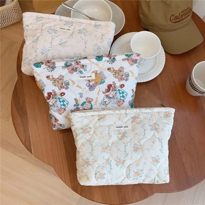 Detailed macro view of quilted floral and bear pattern cotton cosmetic pouches set