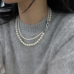 Elegant double-layered pearl necklace with a sparkling diamond-set infinity clasp