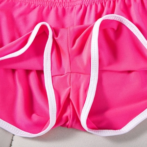 Detailansicht der verstärkten Nähte und des pinkfarbenen Stretchstoffs bei Sportshorts