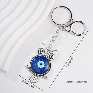 Silver metal owl keychain with blue evil eye glass and feather charm, 12cm length