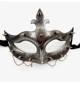 Detail of vintage silver punk mask with gold spikes and decorative metal chains