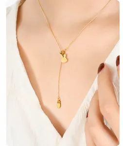 Close-up of 18K gold-plated necklace featuring cute rabbit and carrot pendants on model