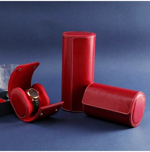 Three red leather watch storage cases on a dark blue background with open interior view
