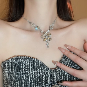 Close-up of a silver flower pendant necklace with sparkling crystals on a model