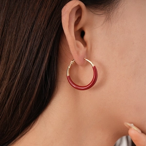 Side view of model wearing vintage red enamel hoop earrings with gold metal accents