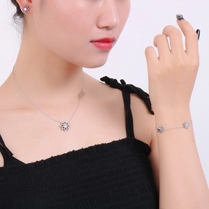 Silver daisy pendant necklace and bracelet set shown on a model against white background