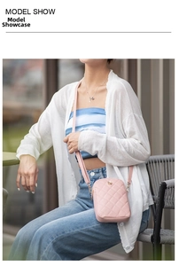 Detail of pink quilted crossbody phone bag shown on model in a casual outdoor setting