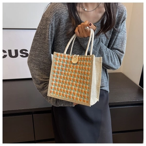 Detail of woven jute tote bag with checkered pattern, rope handles and wooden button
