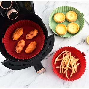 Detailed view of red and green silicone air fryer liners holding wings and fries