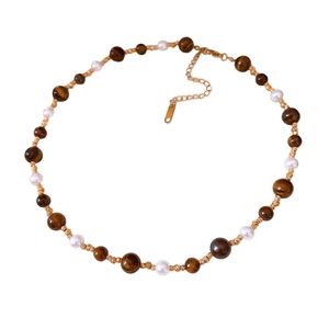 Vintage necklace with tiger eye beads and pearls on a sleek white background