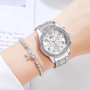 Gros plan d'une montre argentée avec lunette en diamant et bracelet papillon au poignet