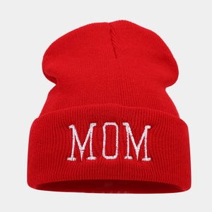 Close-up of red winter knit beanie featuring detailed white MOM letter embroidery