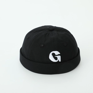 Close-up of black cotton docker hat featuring white G letter embroidery and rolled brim