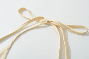 Détail du nœud en satin champagne au dos de la robe d'été en dentelle dos nu