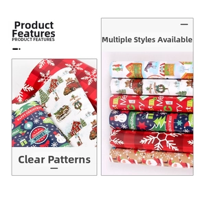 Detail of 80g glossy Christmas wrapping paper with red plaid and festive reindeer patterns