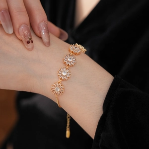 Detailed view of vintage gold flower bracelet with sparkling cubic zirconia on model