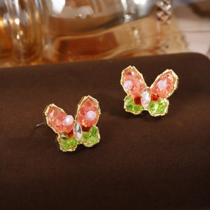 Detailed macro view of colorful butterfly stud earrings with pearl and crystal inlay