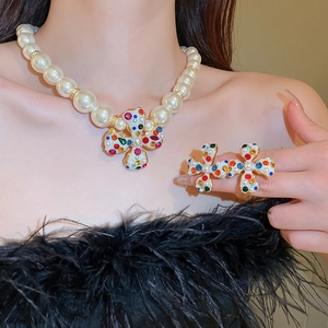 Detail of floral necklace and ring set with multicolored gems and white pearls